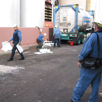 Workers standing on a bridge overlooking a water way outside of a building